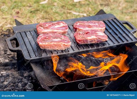 Beef Steaks Grilling On A Cast Iron Plate On A Camp Fire Campfire