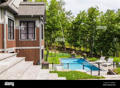 In Ground Swimming Pool And Rear View Of Contemporary Natural Stone And