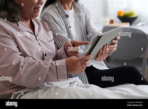 Imagen Recortada De La Madre Mayor Y La Hija Adulta Viendo El Nuevo