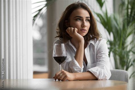 Woman Alone With Red Wine Glass Sitting In The Restaurant And Thinking Leaning Head To Hand