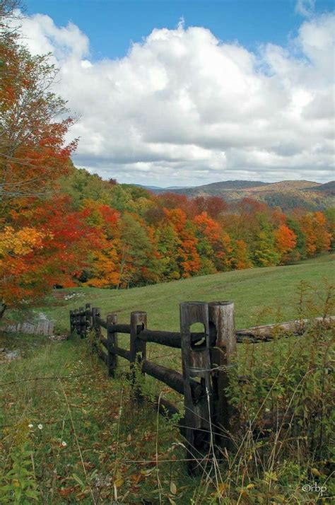 A Wooden Fence In The Middle Of A Field Surrounded By Trees With Fall