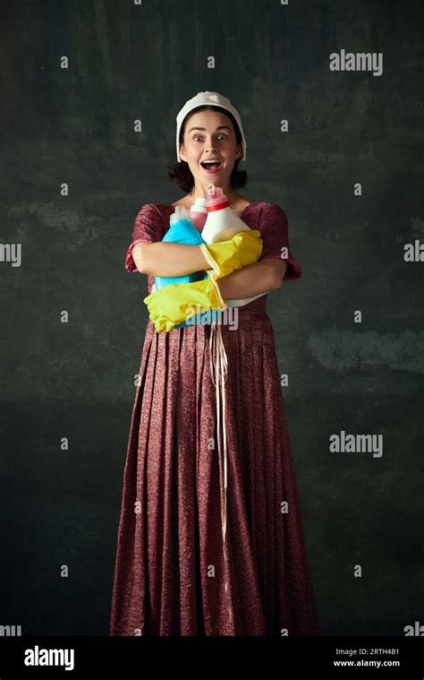 Happy Young Woman In Costume Of Medieval Maid Standing With Laundry