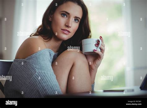 Thoughtful Beautiful Brunette Using Tablet While Drinking Coffee Stock