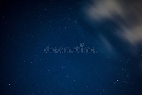 View Of Stars In A Clear Night Sky With Motion In Clouds Moving Acroos