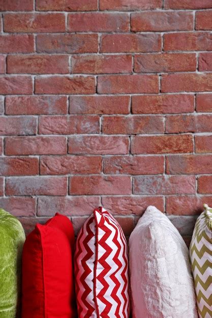 Premium Photo Multicoloured Pillows On A Brick Wall Background