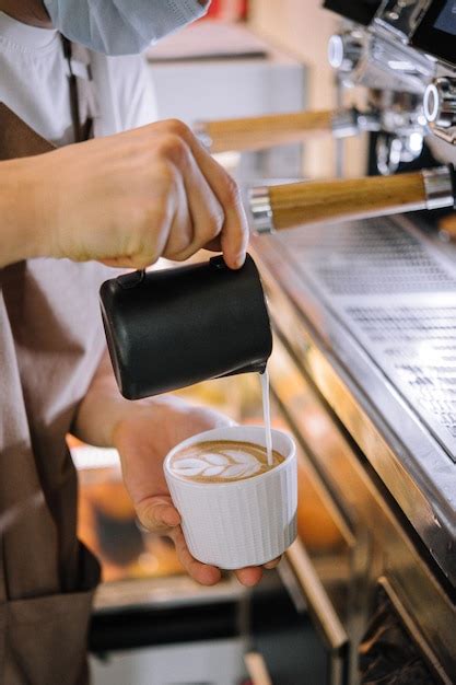 Premium Photo Hands Of A Barista Pouring Warm Milk Into A Cappuccino