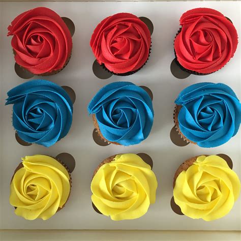 Cupcakes Decorated With Red Yellow And Blue Frosting