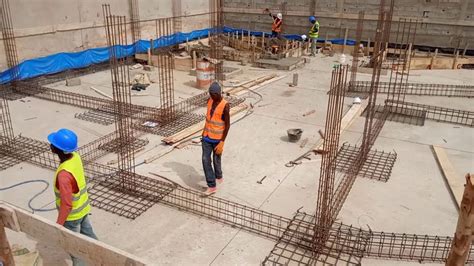 Two Construction Workers Standing In The Middle Of A Building Under