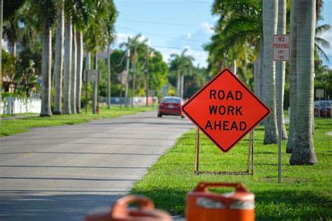 Sinal de trabalho na estrada à frente no local da rua como aviso aos