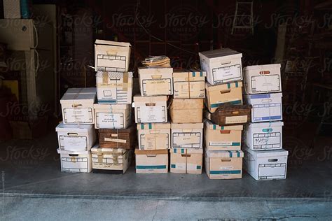 Stacked Cardboard Boxes Filled With Of Documents Sitting In A Garage