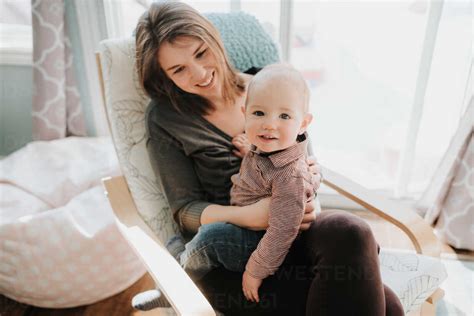 Baby Boy Sitting On Mothers Lap Portrait Stock Photo