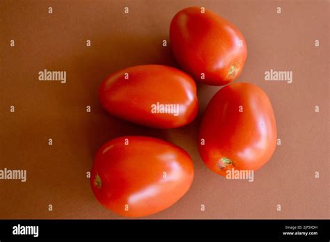 Ripe Roma Tomatoes Against A Simple Background Stock Photo Alamy