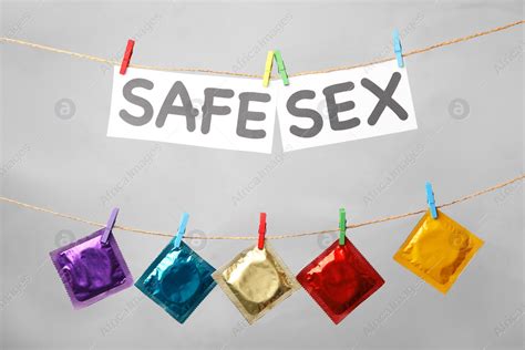 Paper Sheets With Words Safe Sex And Colorful Condoms Hanging On