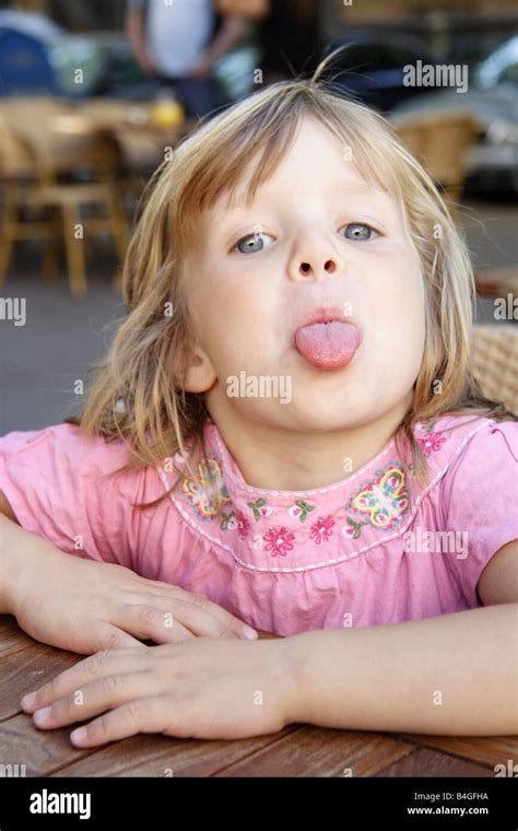 Petite fille qui tire la langue Banque de photographies et dimages à