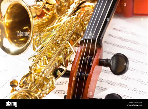 Violoncello tuning pegs and shiny alto saxophone Stock Photo - Alamy