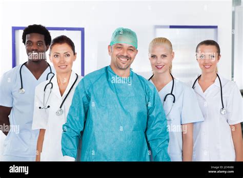 Happy Mature Doctor In Surgical Gown With His Coworkers Stock Photo Alamy
