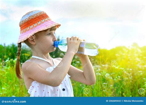 La Petite Fille Boit L Eau D Une Bouteille En Plastique Photo Stock