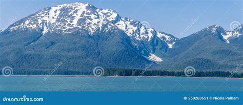 A Panorama View Of The Forested Shoreline And Mountain Backdrop Of The