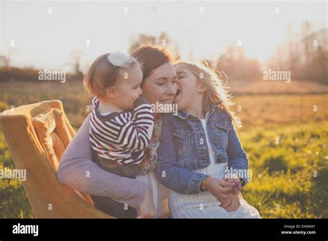 A Mother Holds Her Two Daughters Stock Photo Alamy