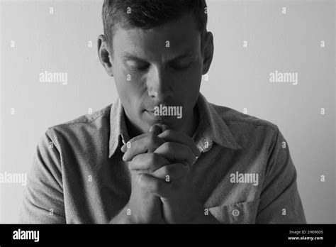 Man With Hands Clasped Together For Prayer On Light Background Black