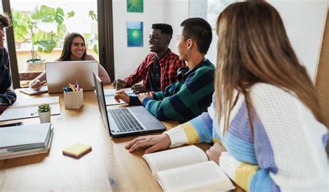 Estudiantes Multirraciales Que Leen Libros Y Usan La Computadora