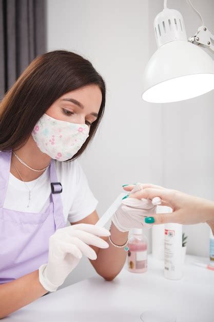 Disparo vertical de manicurista mujer presentación de uñas del cliente