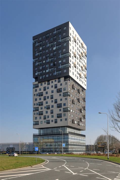 A Very Tall Building Sitting On The Side Of A Road Next To A Green Field