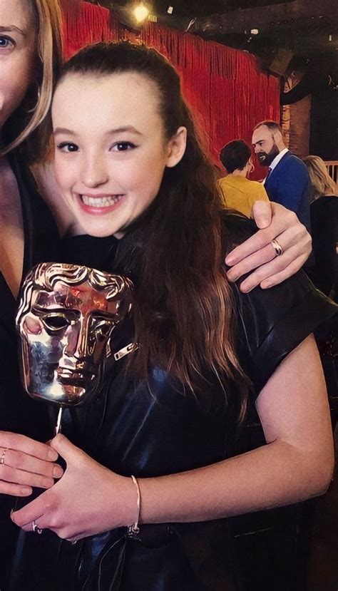 Two Women Hugging Each Other While Holding An Award