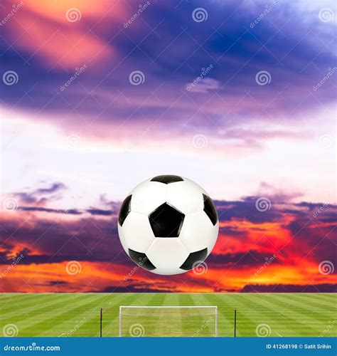 Soccer Ball With Soccer Field Against Beautiful Sunset Stock Photo