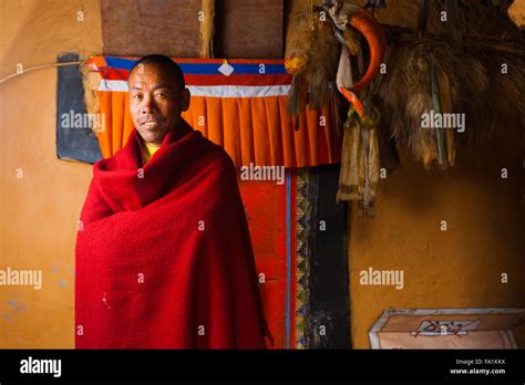 Smiling Ethnically Tibetan Monk Standing In Inner Courtyard Against