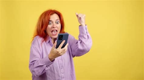 Excited Mature Redheaded Woman Celebrating While Using The Mobile Phone People Stock Footage Ft