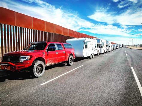 Line Of Rvs Against Mexico Border Wall