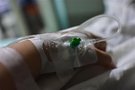 Premium Photo Cropped Image Of Hand With Iv Drip On Bed