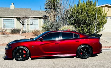 Red Dodge Charger Hellcat Parked In Front Of House