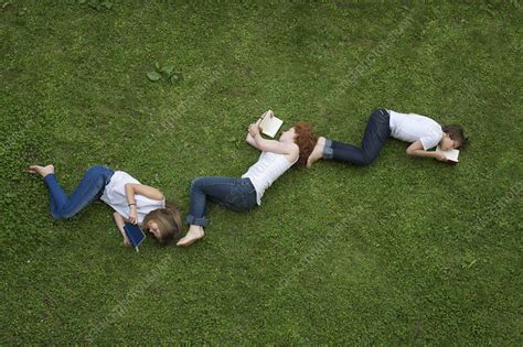 Teenagers Laying In Grass Reading Books Stock Image F004 9675