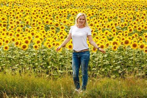 Woman With Sunflowers Enjoying Nature And Laughing On Summer Sunflower