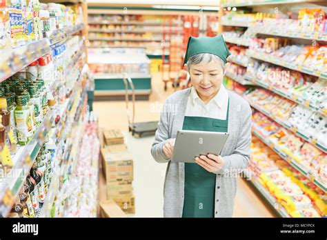 Senior Woman Checking Restock In Supermarket Stock Photo Alamy