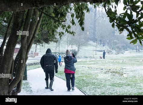 People Walking In Snow In Trenance Gardens In Newquay Cornwall Stock