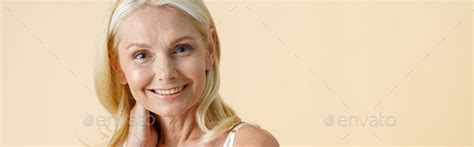 Portrait Of Charming Mature Woman With Blonde Hair In White Underwear