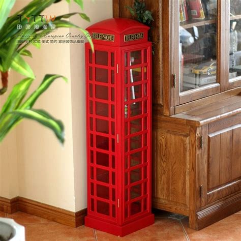 A Red Phone Booth Sitting Next To A Potted Plant