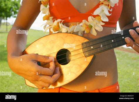 Closeup Of Hawaiian Woman In Orange Bikini With Orchid Lei Playing
