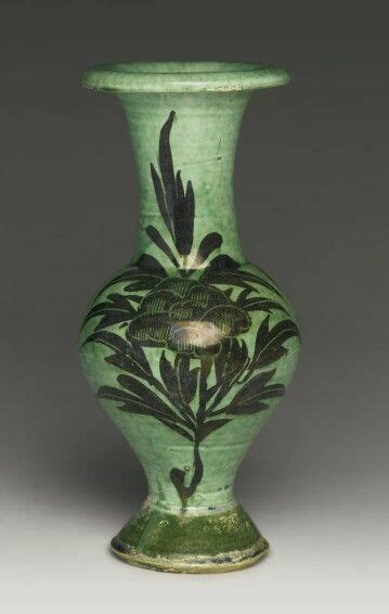 A Green Vase With Leaves Painted On It