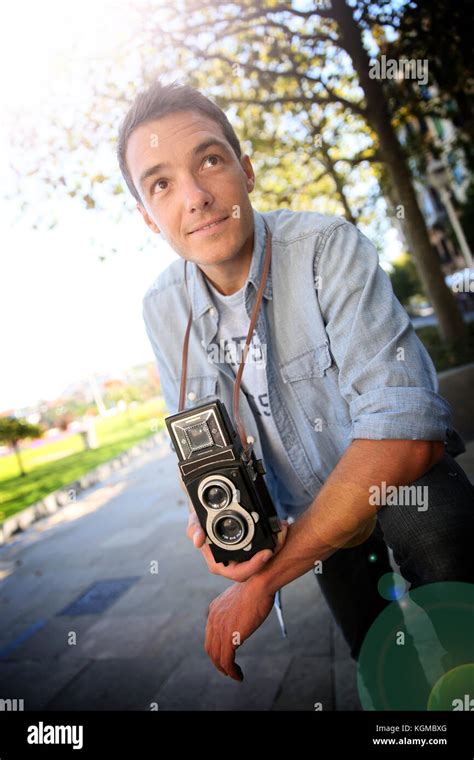 Young man holding vintage camera Stock Photo - Alamy