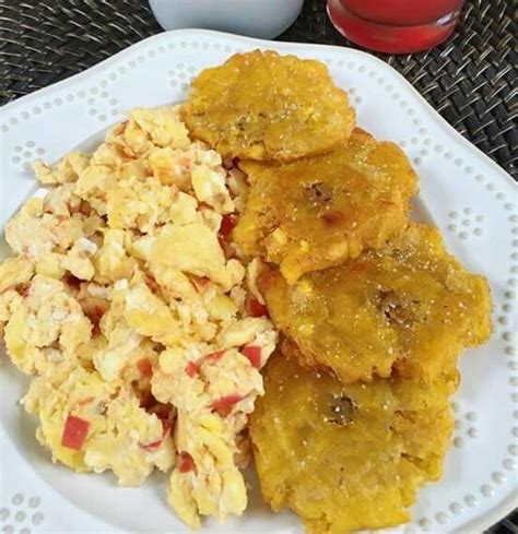 A White Plate Topped With Breakfast Foods Next To A Cup