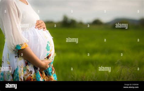 Beautiful Pregnant Woman Wearing White Floral Dress Affectionately