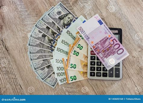 Dollars, Euro and and Calculator on Wooden Background Stock Photo ...