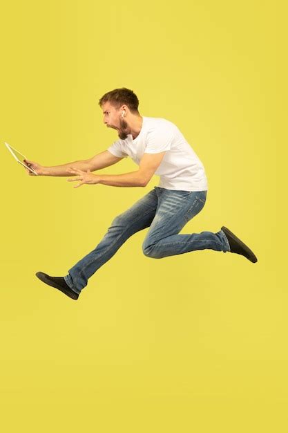 Retrato De Corpo Inteiro Do Homem Pulando Feliz Em Fundo Amarelo Foto