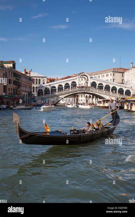 Couple Enjoying A Ride In A Gondola Near The Rialto Bridge On Grand