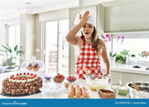 Beautiful Young Brunette Pastry Chef Woman Cooking Pastries At The Kitchen Surprised With Hand