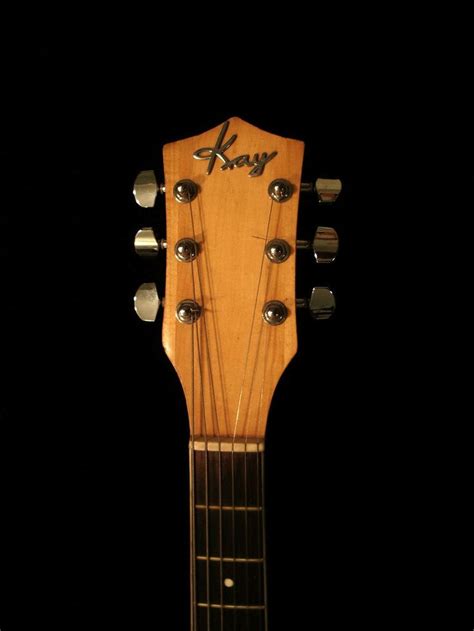 An Acoustic Guitar Is Shown Against A Black Background